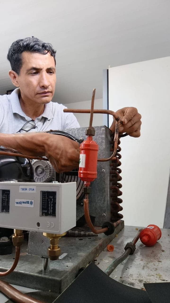 Técnico de FENT RACE trabajando en un equipo de climatización industrial
